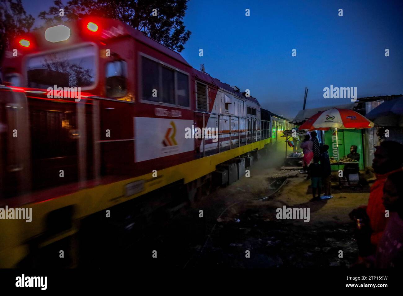 Am späten Abend fährt der Personenzug von Nairobi nach Kisumu an Kibera Slum in Nairobi vorbei. Ein Blick durch den Alltag in Kibera, dem heutigen afrikanischen Stadtteil L Stockfoto