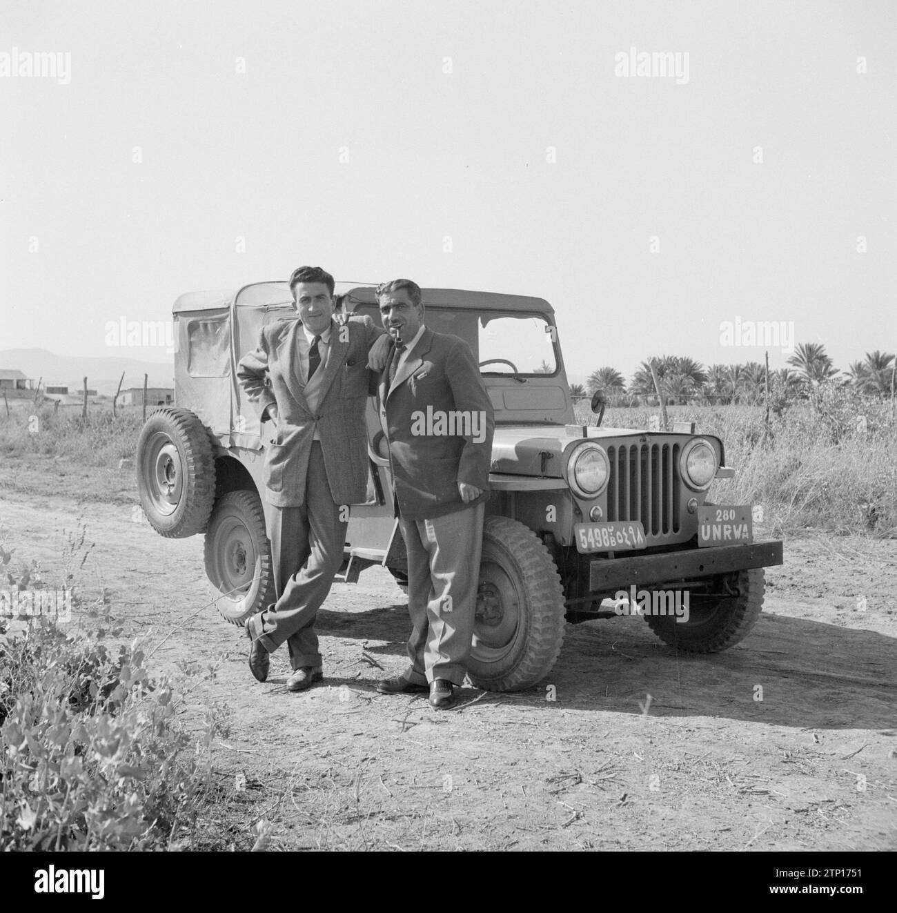 Zwei Personen der UN-Flüchtlingsorganisation stehen neben ihrem Jeep Ca. 1950-1955 Stockfoto
