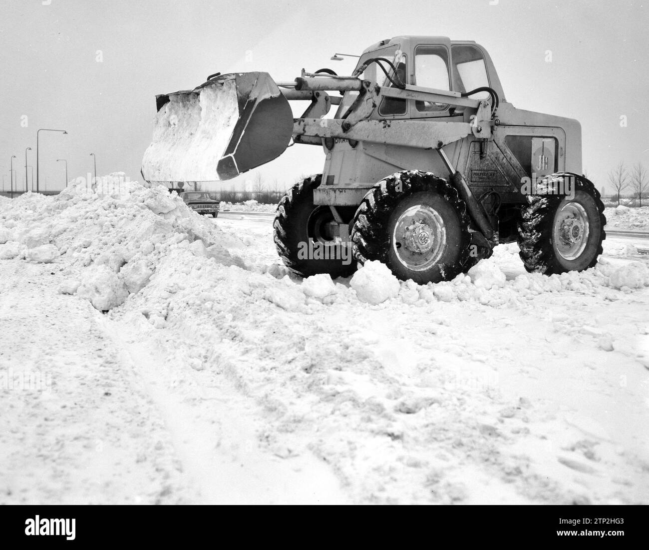 Der Zuiderzeeweg über die Schellingwoudebrug wurde wieder eröffnet. Planierraupe ist mit Schneeräumung beschäftigt. Januar 1963 Stockfoto