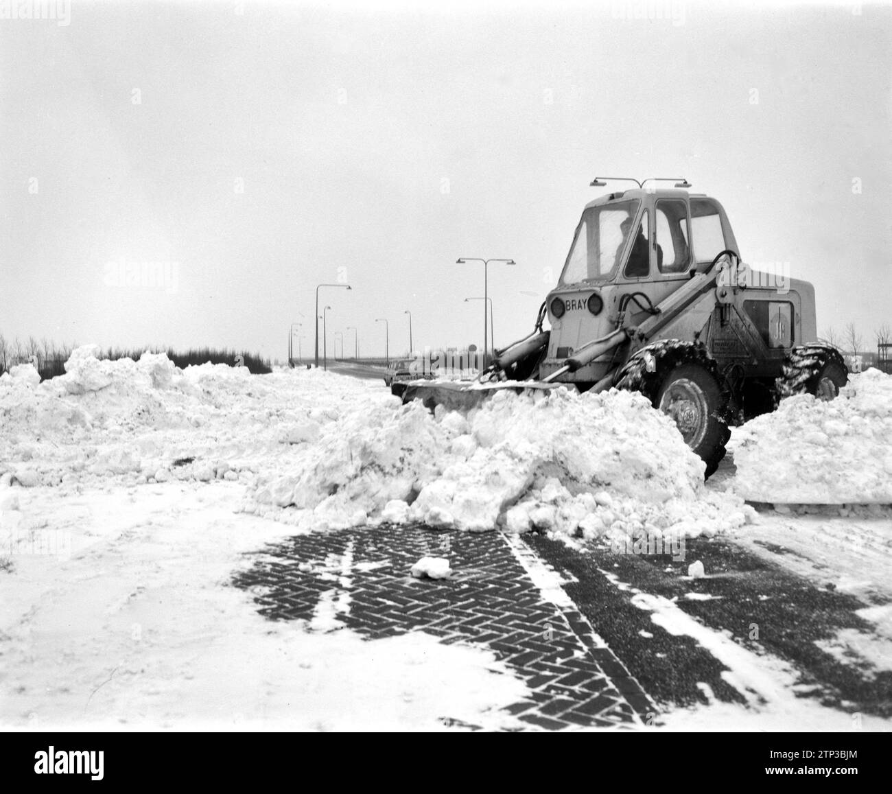 Der Zuiderzeeweg über die Schellingwoudebrug wurde wieder eröffnet. Planierraupe ist mit Schneeräumung beschäftigt. Januar 1963 Stockfoto