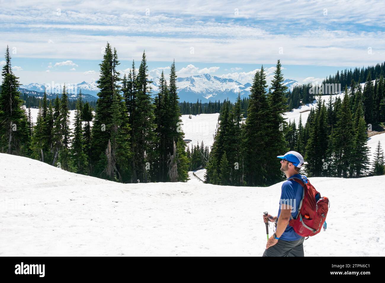 Ein Wanderer hält an, um die weitläufige Aussicht vom schneebedeckten Panorama Ridge Trail zu bewundern Stockfoto