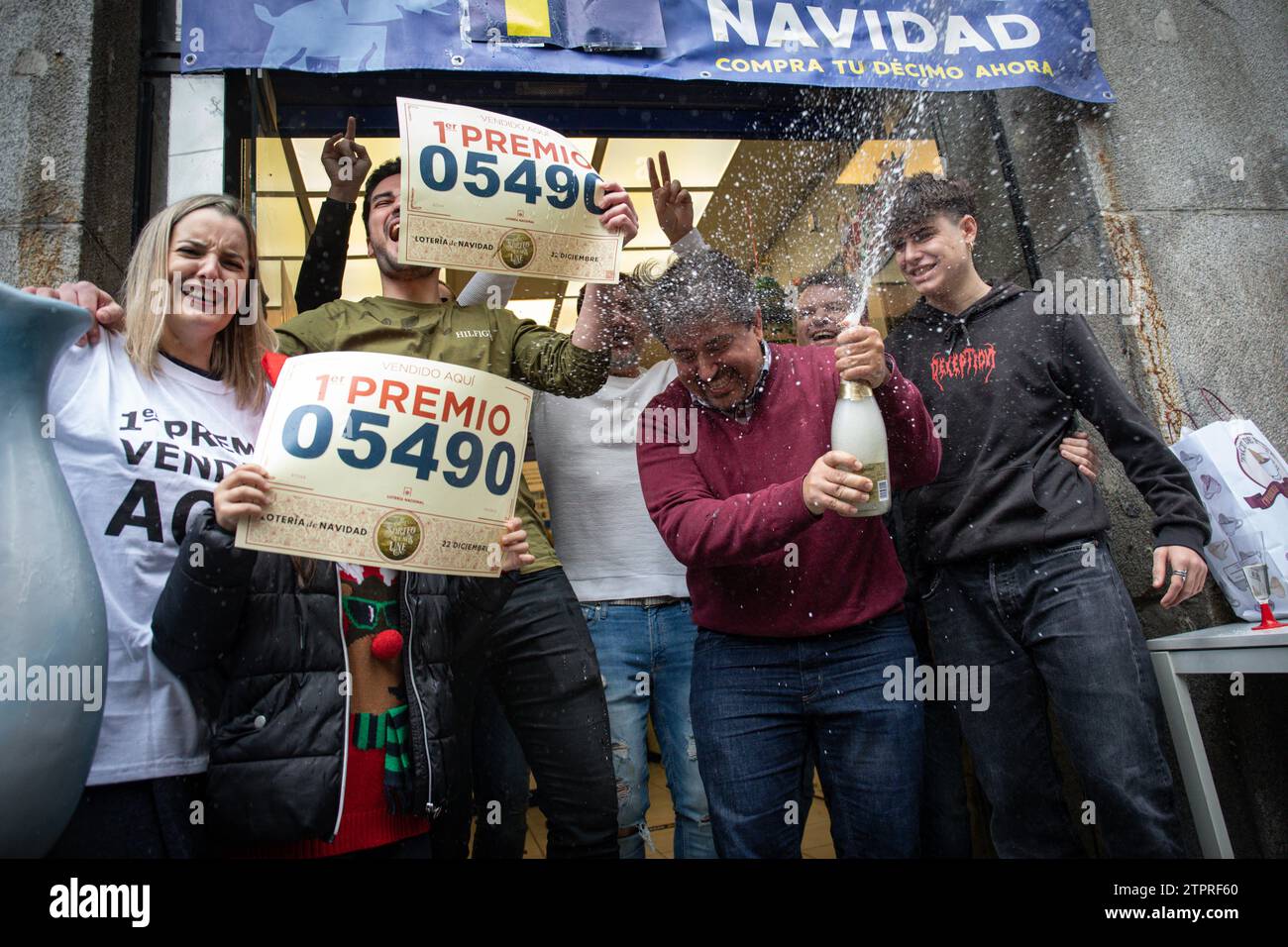 Madrid, Spanien. Dezember 2022. Eine Gruppe von Personen feiert den ersten Lottopreis mit Plakaten und den Gewinnzahlen. Die Manager des nationalen Lotteriebüros „El Elefante azul“ in der Madrider Straße Arenal feiern den ersten „Jackpot“-Preis in der Weihnachtslotterie, der in ihrer Lotterieverwaltung erzielt wurde. Die Weihnachtslotterie wird jeden 22. Dezember in Spanien gefeiert. (Credit Image: © David Canales/SOPA Images via ZUMA Press Wire) NUR REDAKTIONELLE VERWENDUNG! Nicht für kommerzielle ZWECKE! Stockfoto