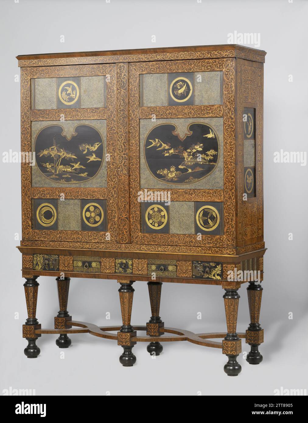 Schrank, anonym, ca. 1700 - ca. 1705 Eichenschrank mit mehreren Hölzern verklebt und mit japanischer Lackierung und eingeschnittener Roggenfassade eingelegt. Die sechs Balusterbeine des Fahrgestells sind durch zwei doppelte X-förmige Kreuze verbunden; die obere Linie enthält fünf mit Lack verzierte Schubladen. Beide Türen weisen jeweils drei Farbtafeln mit Roggenfassade auf; die mittlere trägt eine Landschaft mit Vögeln in Schildform. Die Ober- und Unterplatten sowie die Paneele an den Seiten sind mit Pseudo-mons verziert; die Beine und der Schrank sind mit Seetang-Marqueterie verziert. Niederländisches Holz (pflanzliches Material). Eiche (Holz). Nussbaum (Hartholz Stockfoto