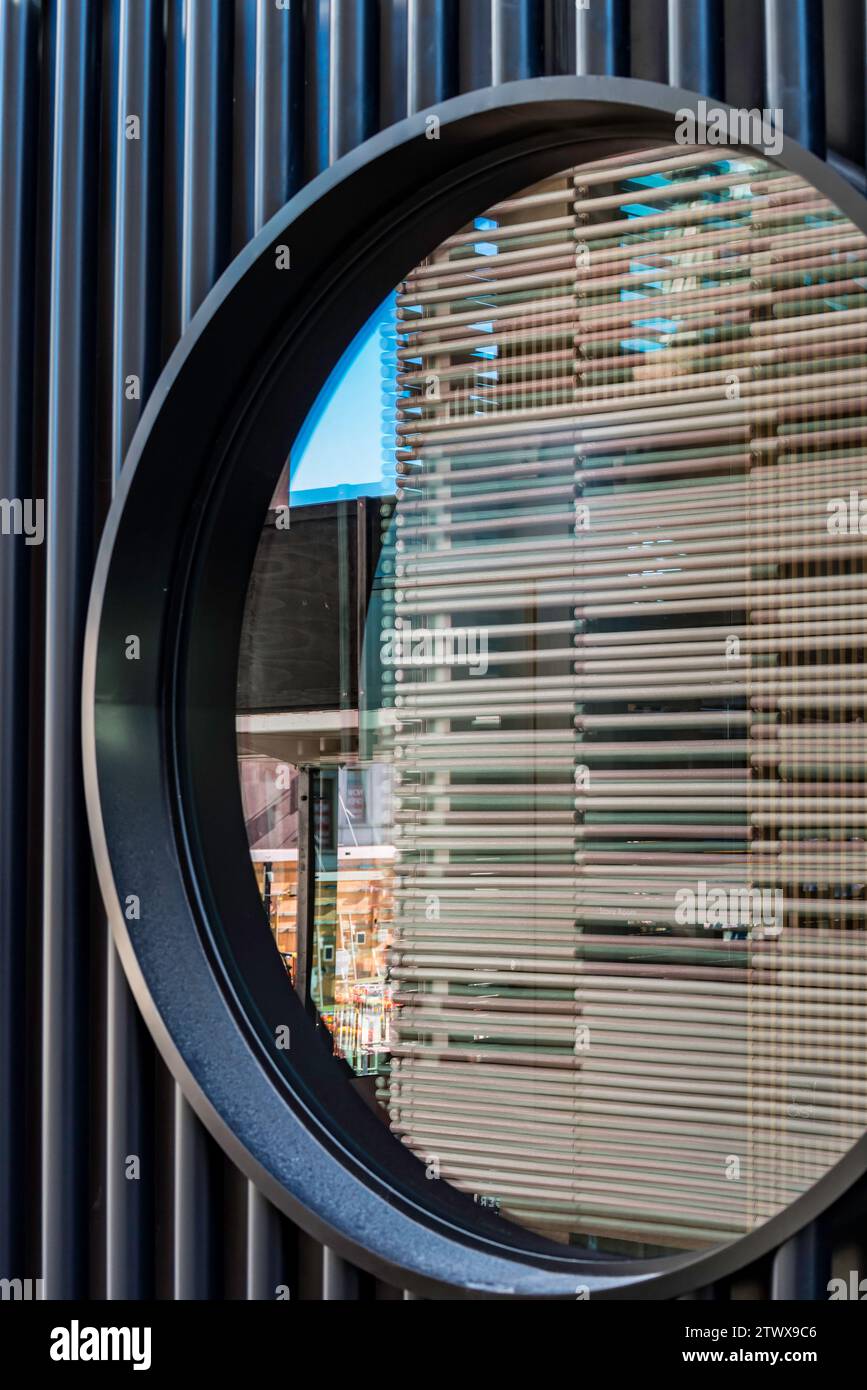 Reflexionen in einem kreisförmigen Fenster, eingebettet in eine vertikal ausgelegte Stahlwand, Teil des neuen von Adjaye Associates entworfenen Plaza Building in Sydney, Aust. Stockfoto