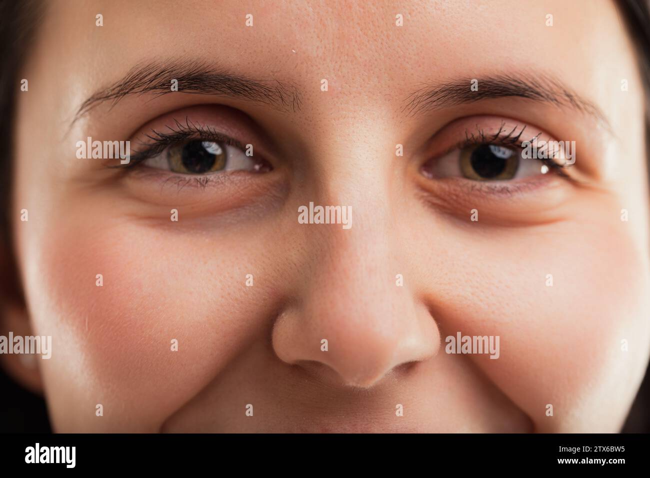 Wimpern umrahmen die Augen der Frau und betonen ihre Tiefe und die Geschichten, die sie erzählen könnten Stockfoto