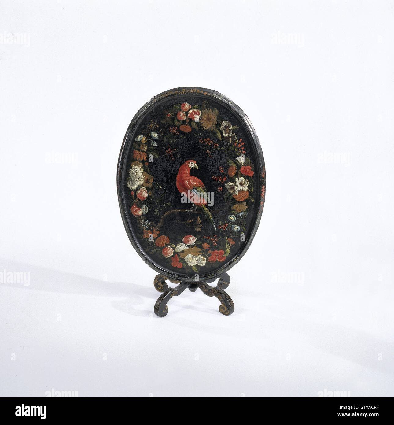 Klapptisch aus schwarz lackiertem ohne Klappblatt. Abgeschirmtes Magazin., Willem Hendrik Wilhelmus van Royen (zugeschrieben), ca. 1690 - ca. 1710 Klapptisch, aus schwarz lackiertem ohne Art, mit ovaler Klappplatte. Das Blatt ist mit einem bunten Blumenkranz um einen Papagei bemalt, der auf einem Ast sitzt; der aufrechte Rand ist mit Blättern und Blumen verziert, nur ein bunten, alles auf schwarzem Hintergrund. Die Blattscharniere sind hinten auf einem kleinen Vierkantflügel befestigt und können mit einem schwarzen Verriegelungsschloss angeklickt werden. Die Beine in Balusterform, die in einem Knopf enden, und Stockfoto