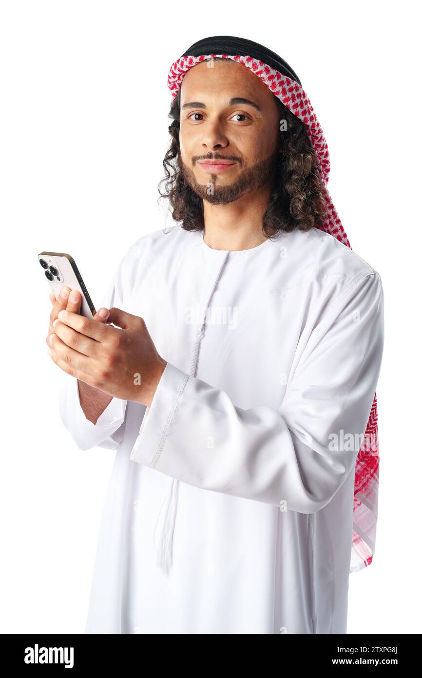Junger arabischer Mann in traditioneller Kleidung, der ein Smartphone auf weißem Hintergrund benutzt Stockfoto