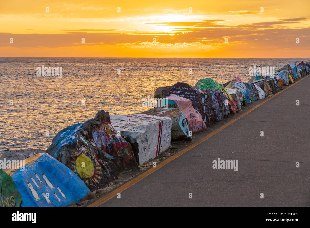 Große gemalte Felsen entlang eines Wellenbrechers bei Sonnenaufgang in Port Macquarie an der Nordküste von New South Sales, Australien. Stockfoto