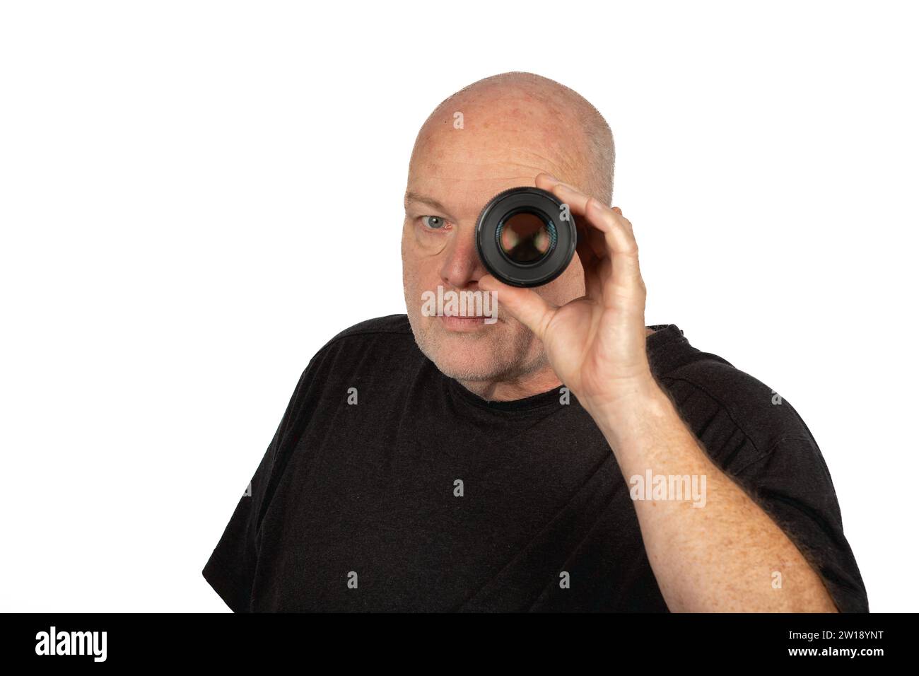 Erfahrener 58-jähriger kaukasischer Mann in grauem T-Shirt mit Blick durch Kameraobjektiv - Kopierraum verfügbar Stockfoto