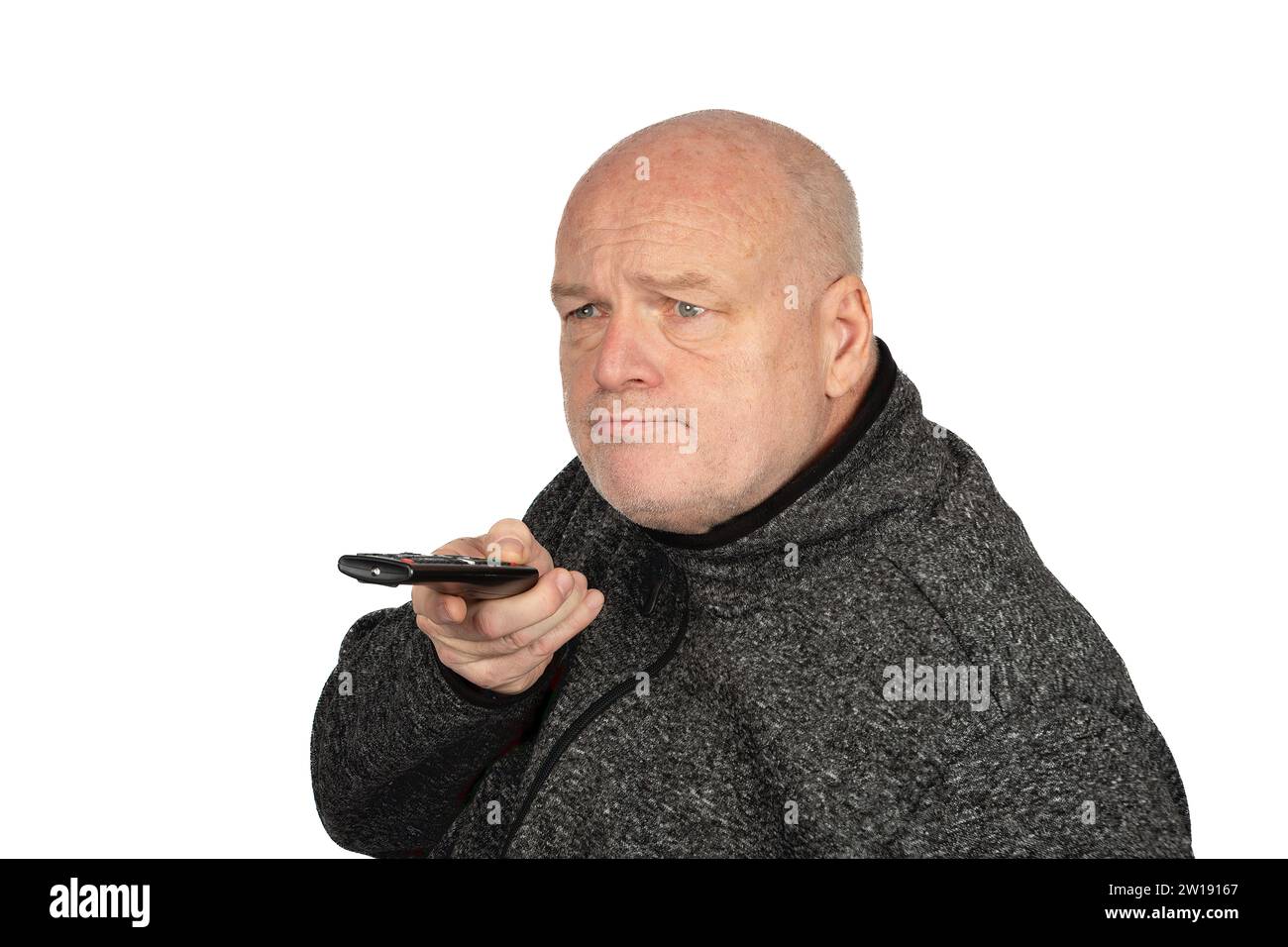Reifer kaukasischer Mann in grauem Pullover mit TV-Fernbedienung - Kopierraum verfügbar Stockfoto