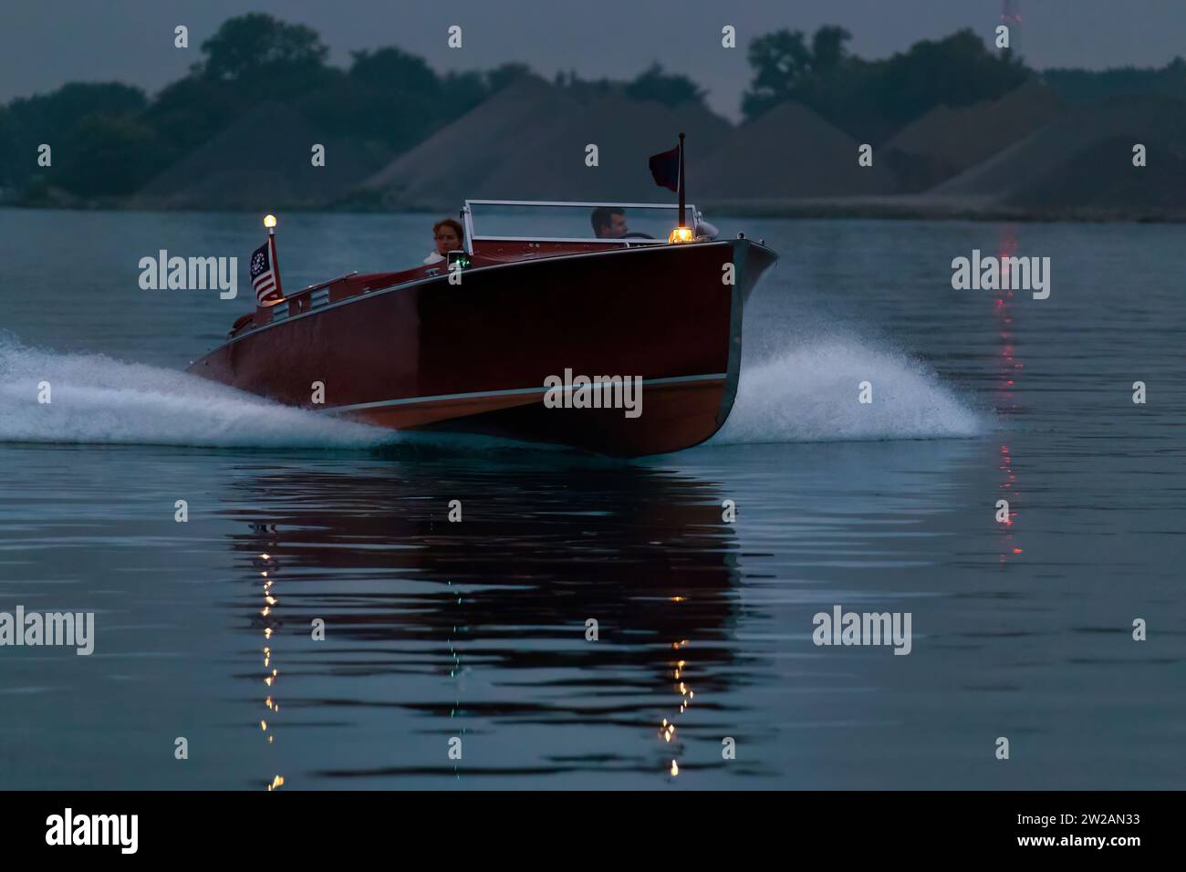 Zwei Personen, die in einem alten Schnellboot in der frühen Morgenröte fahren. Stockfoto