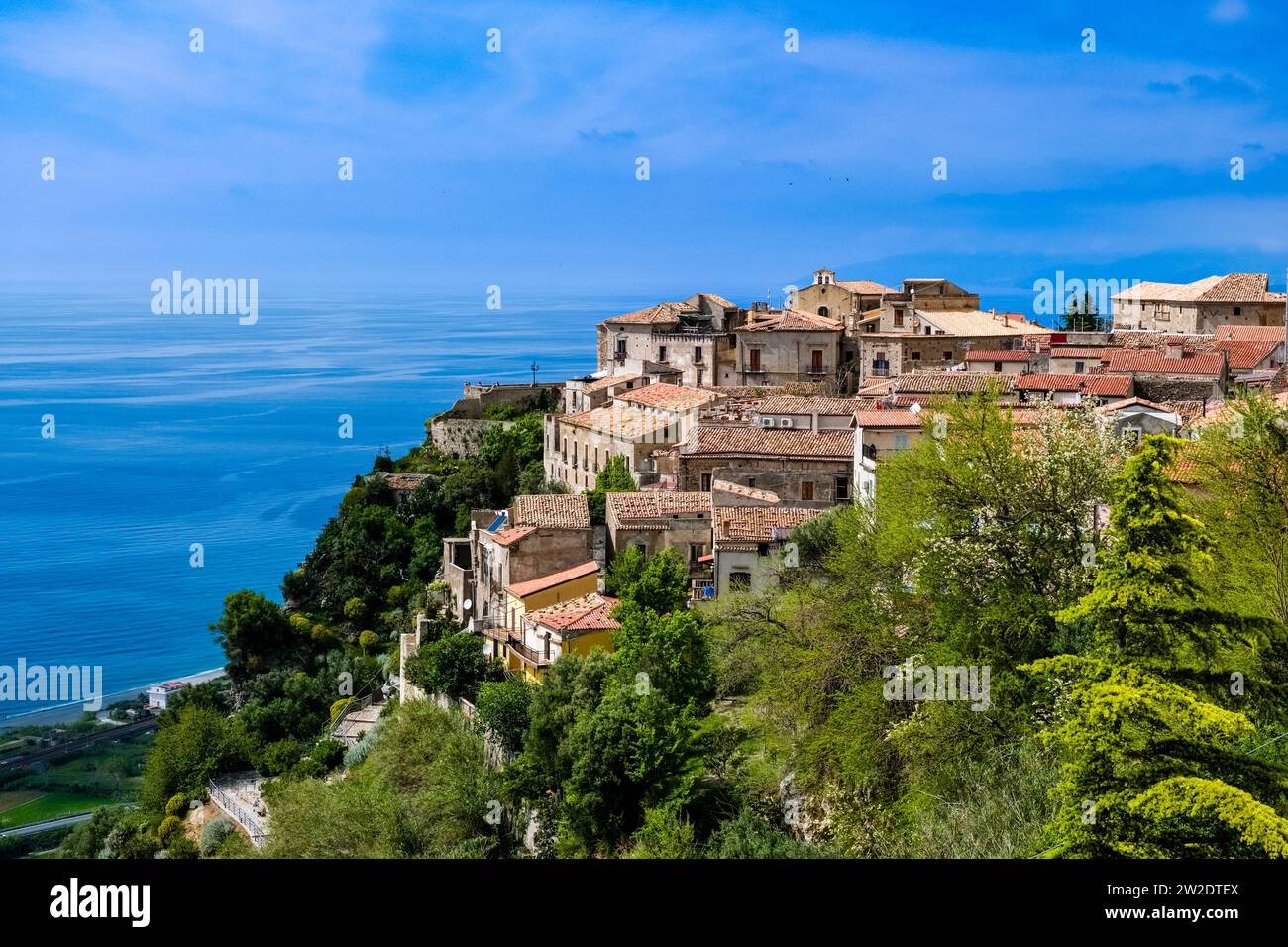 Häuser der kleinen Stadt Fiumefreddo Bruzio, die auf einer felsigen Klippe mit Blick auf das Mittelmeer liegt. Stockfoto