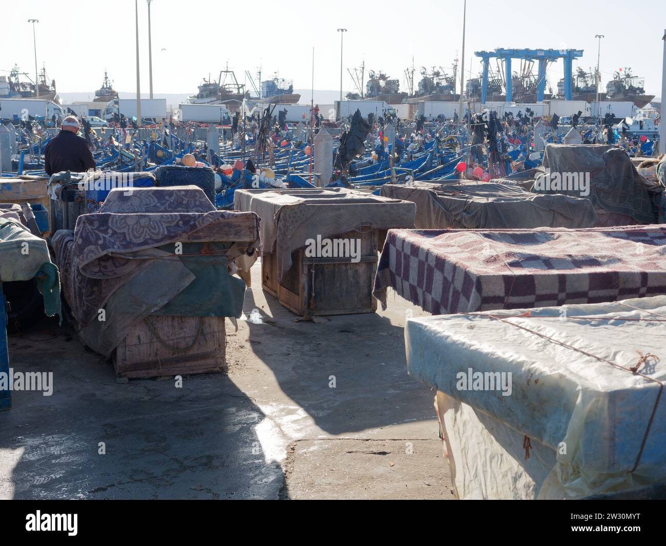 Kisten mit Haifischnetzen mit Fischerbooten im Hafen von Essaouira, der „windigen Stadt“, Marokko. Dezember 2023 Stockfoto