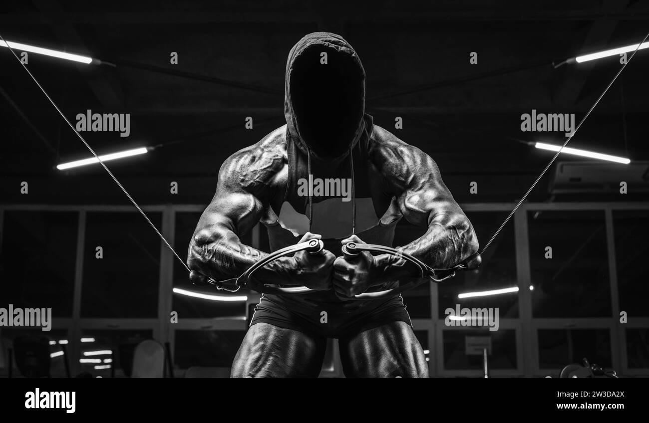 Nouname-Bild eines leistungsstarken Athleten, der im Fitnessstudio trainiert. Fitness- und Bodybuilding-Konzept. Gemischte Medien Stockfoto