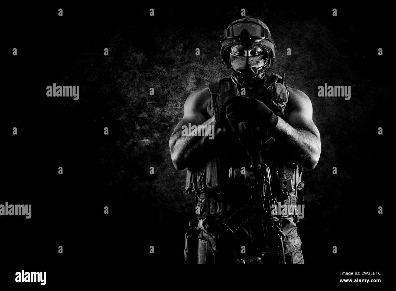 Der Soldat der Spezialeinheit steht mit einer automatischen Waffe im Vorteil. Gemischte Medien Stockfoto