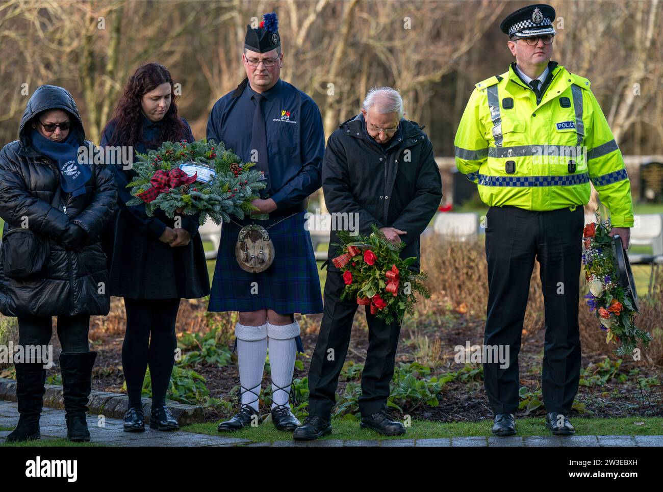 Die Menschen versammeln sich, um ihren Respekt bei einer Kranzniederlegung zum 35. Jahrestag des Bombenanschlags auf Lockerbie im Memorial Garden, Dryfesdale Cemetery, Lockerbie, zu erweisen. Am 21. Dezember 1988 explodierte der Pan am Flug 103 über der Stadt Dumfries und Galloway, 40 Minuten nach dem Flug von London nach New York. Alle 259 Passagiere und Besatzungsmitglieder wurden getötet, darunter 35 Studenten der University of Syracuse sowie 11 Einwohner von Lockerbie. Bilddatum: Donnerstag, 21. Dezember 2023. Stockfoto