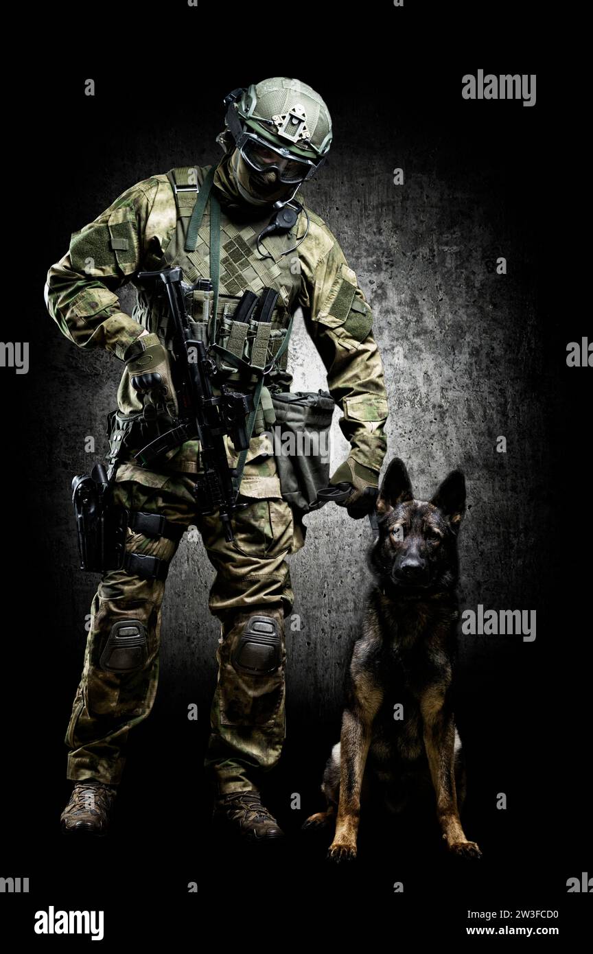 Hundeführer posiert im Studio mit einem ausgebildeten Hirten. Das Konzept des Grenzschutzes, der Flughäfen, der Räumung. Gemischte Medien Stockfoto