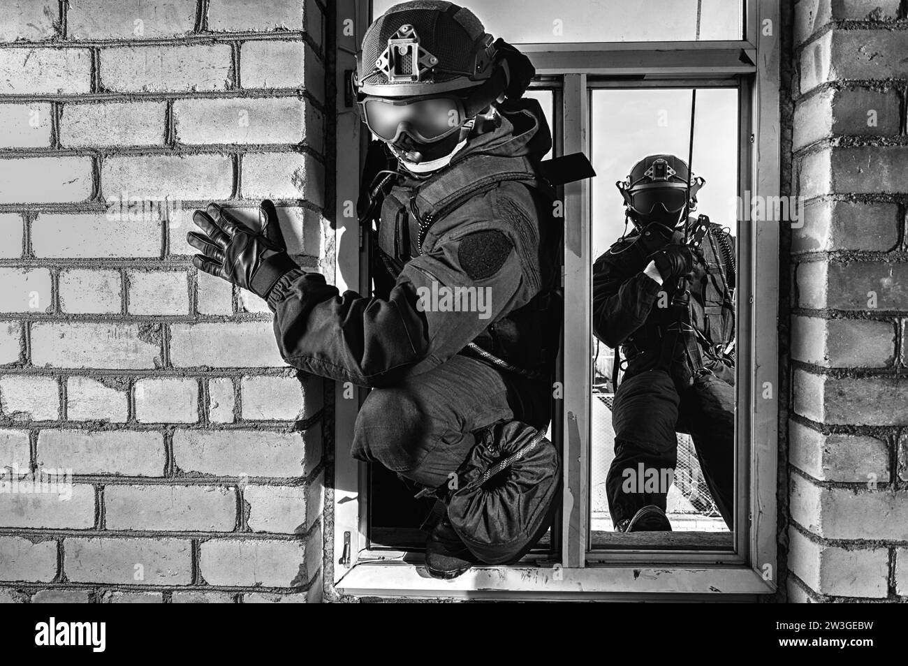 Eine Gruppe von Spezialkräften stürmt das Gebäude durch das Fenster. Schulungen des SWAT-Teams. Anti-Terror-Konzept. Kletterer. Gemischte Medien Stockfoto