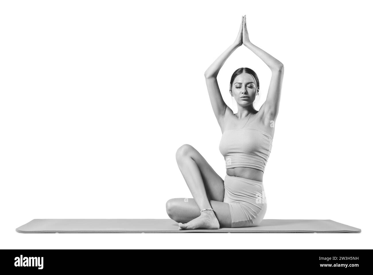 Sportliche junge Frau, die Yoga übt. Isoliert auf weißem Hintergrund. Das Konzept eines gesunden Lebensstils und des natürlichen Gleichgewichts zwischen Körper und Stockfoto