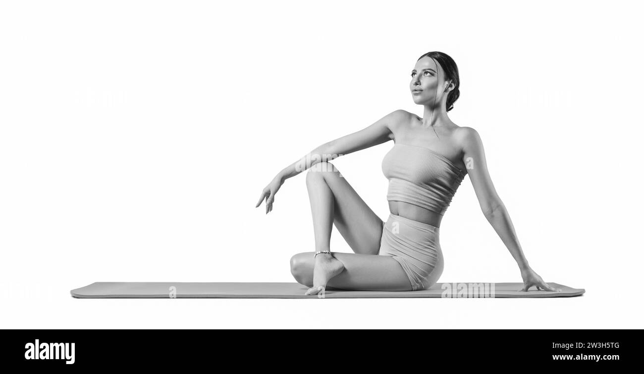 Sportliche junge Frau, die Yoga übt. Isoliert auf weißem Hintergrund. Das Konzept eines gesunden Lebensstils und des natürlichen Gleichgewichts zwischen Körper und Stockfoto