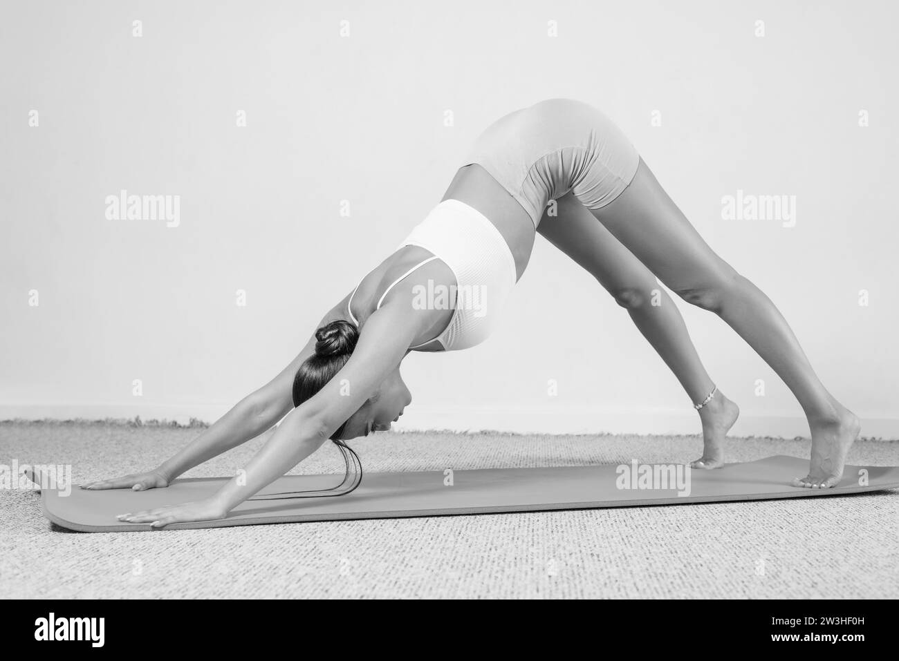 Sportliche junge Frau, die Yoga übt. Isoliert auf weißem Hintergrund. Das Konzept eines gesunden Lebensstils und des natürlichen Gleichgewichts zwischen Körper und Stockfoto