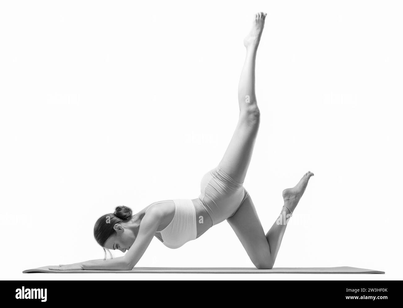 Sportliche junge Frau, die Yoga übt. Isoliert auf weißem Hintergrund. Das Konzept eines gesunden Lebensstils und des natürlichen Gleichgewichts zwischen Körper und Stockfoto