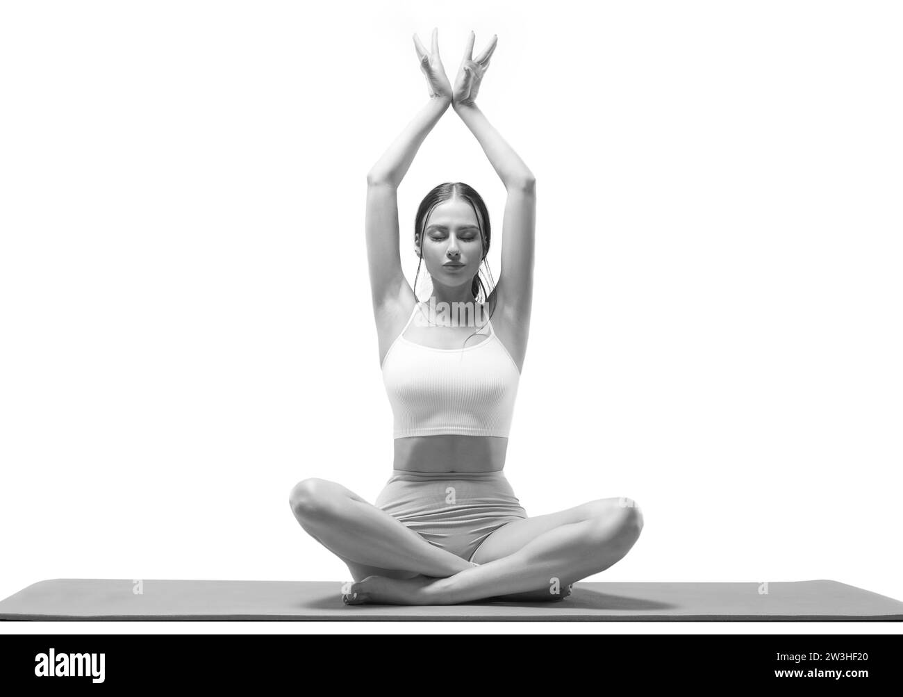 Sportliche junge Frau, die Yoga übt. Isoliert auf weißem Hintergrund. Das Konzept eines gesunden Lebensstils und des natürlichen Gleichgewichts zwischen Körper und Stockfoto