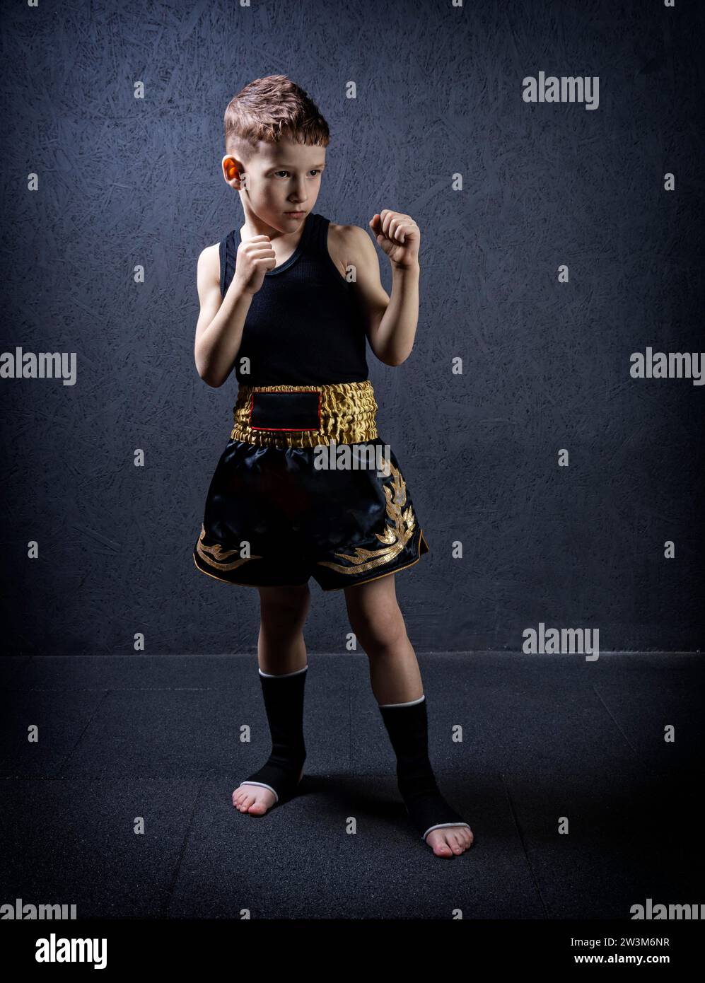 Porträt eines Kindes in Sportgeräten. Das Konzept des Kickboxens, muay thai, mma, gesunder Lebensstil. Gemischte Medien Stockfoto