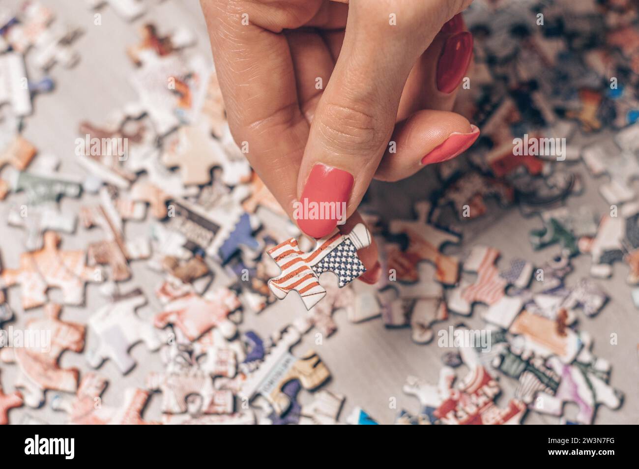 Die Frau hält Puzzle mit der us-Flagge. Wirtschaftliches und politisches Konzept. Gemischte Medien Stockfoto