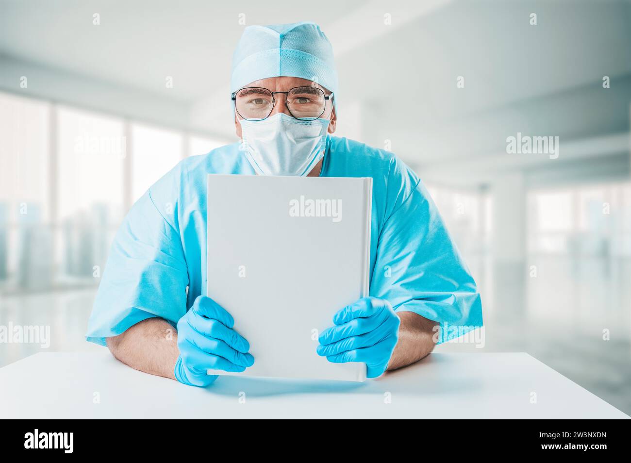 Der Doktor hält ein weißes Nachschlagebuch vor sich. Medizinkonzept. Gemischte Medien Stockfoto