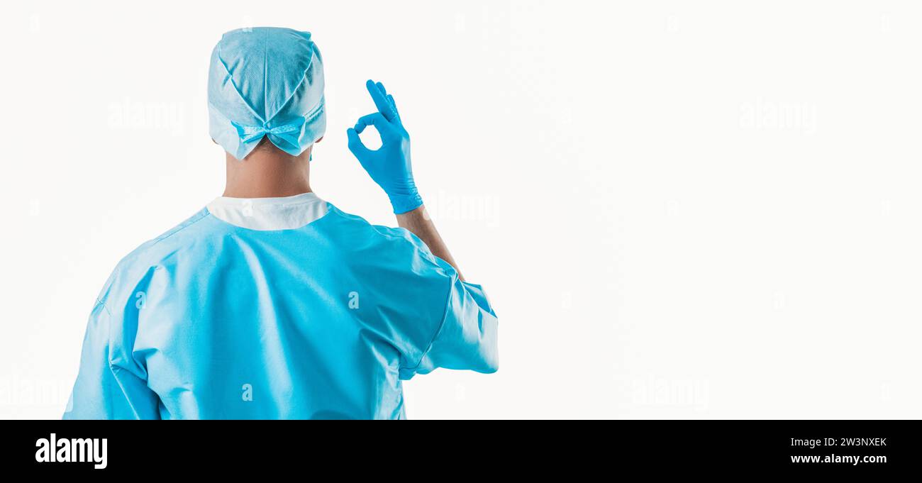 Porträt eines Arztes auf weißem Hintergrund. Er zeigt ein OK-Zeichen. Die Aussicht von hinten. Medizinkonzept. Gemischte Medien Stockfoto