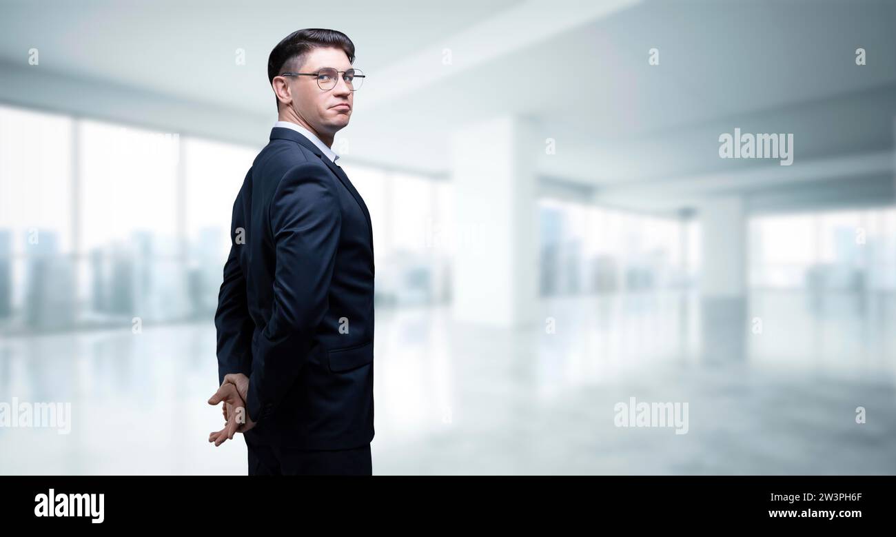 Porträt eines Geschäftsmannes im Anzug. Er steht im Büro eines Wolkenkratzers. Geschäftskonzept. Gemischte Medien Stockfoto