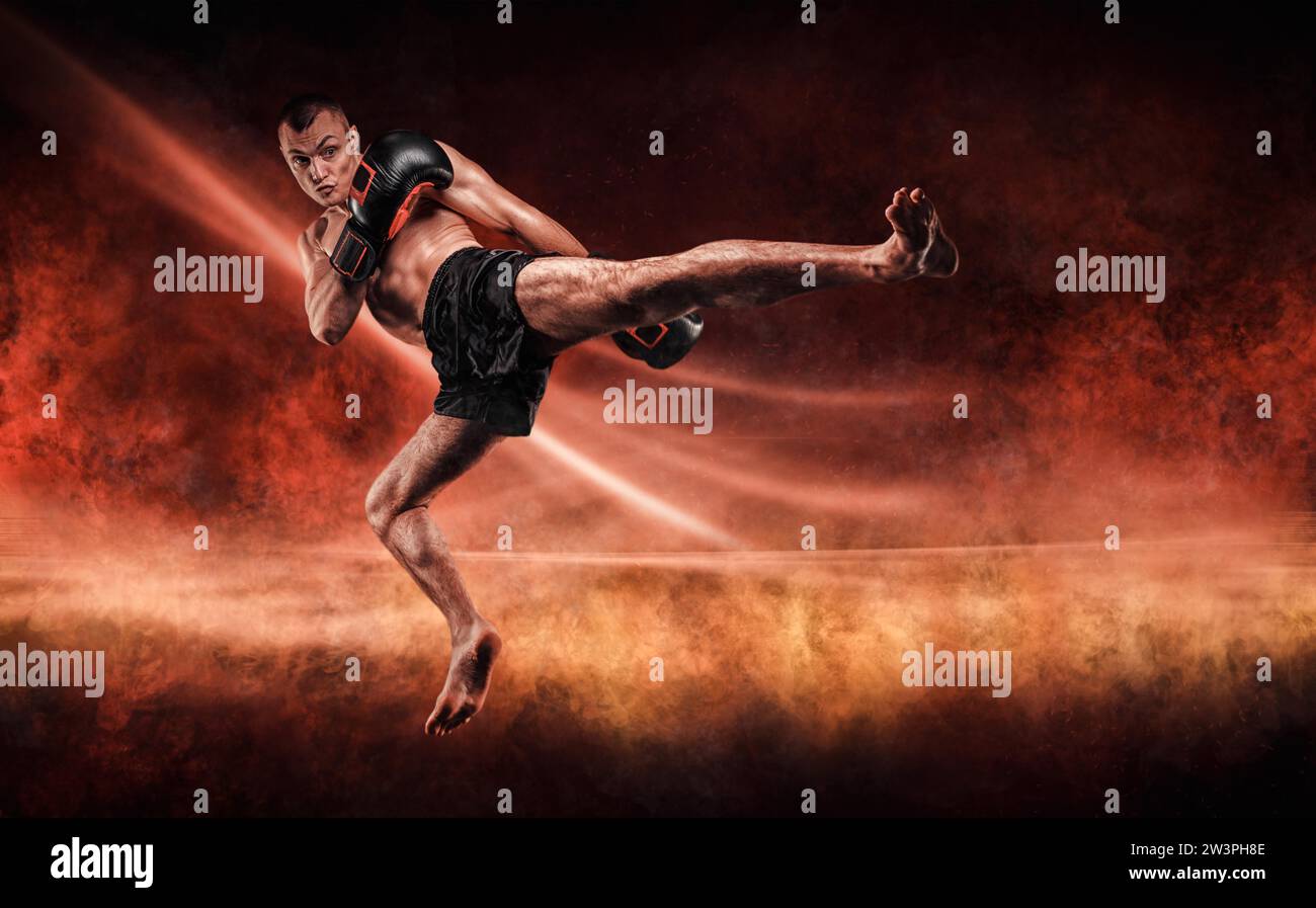 Professioneller Kickboxer springt mit gestrecktem Knie. Feurige Arena. Gemischte Kampfkunst. Sportkonzept Stockfoto