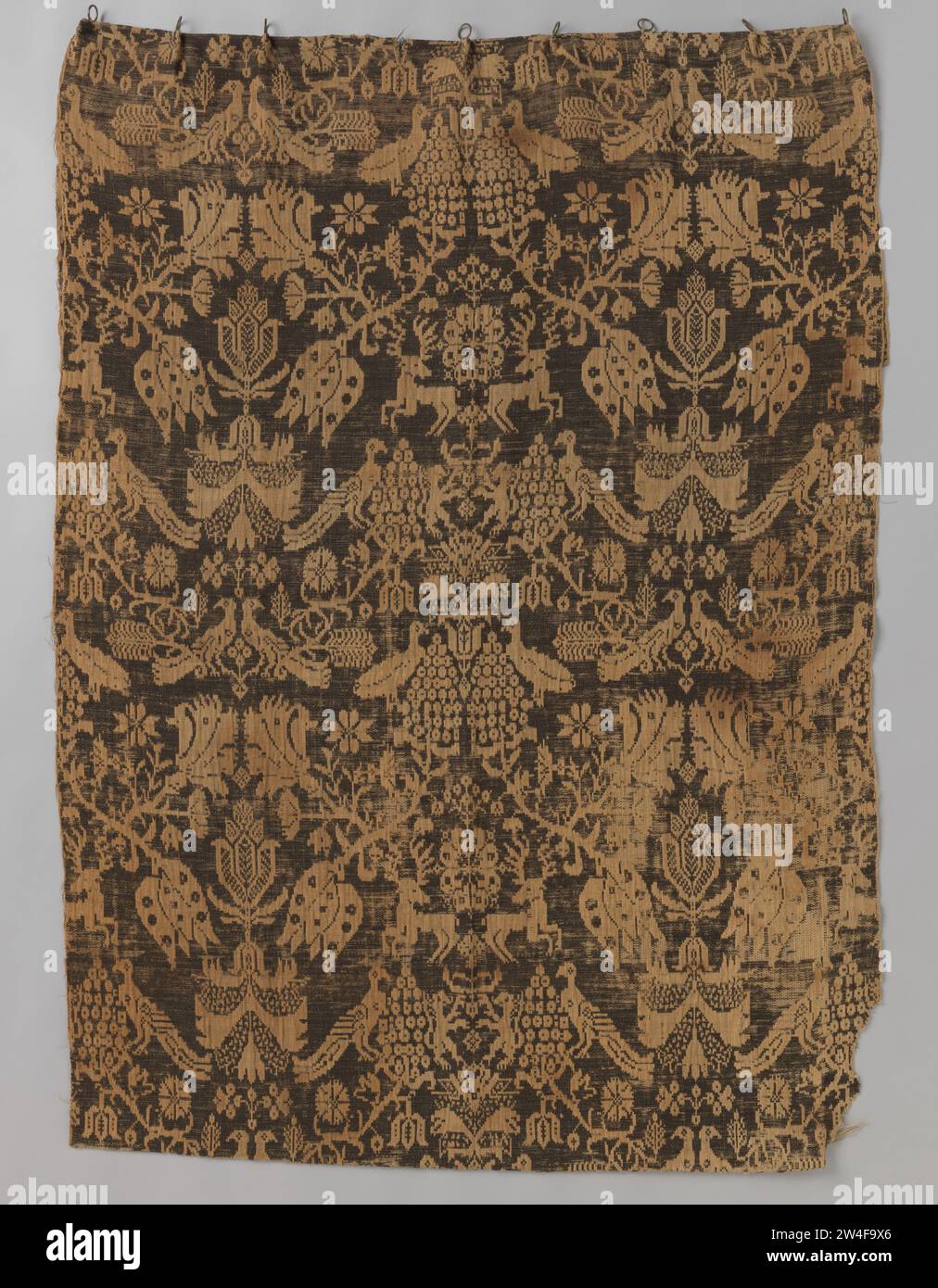 Bettvorhang aus 'beidwandigem' Gewebe in Schwarz-weiß , 1650 - 1700 Bettvorhang aus sogenanntem 'beidwandigem' Gewebe. Das Schwarzweiß-Muster ist unendlich und symmetrisch auf vertikalen Achsen. Die Zeichnung besteht aus Vögeln, Hirschen, Palmen, Nelken, Tulpen und Trauben. Die Textur ist ein doppeltes Gewebe, so dass auf der einen Seite das Muster schwarz auf schwarz auf der anderen Seite schwarz-weiß ist. Der Vorhang besteht aus Wolle und Leinen. Ostfrieslandwolle. Leinen (Material) Bettvorhang aus sogenanntem „beide Wände“-Gewebe. Das Schwarzweiß-Muster ist unendlich und symmetrisch auf vertikalen Achsen. Das Drawi Stockfoto