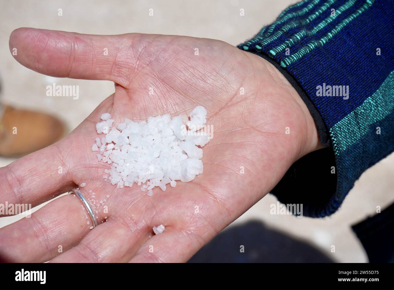 Eine Hand, die Salz aus den bolivianischen Salzgärten hält. Stockfoto