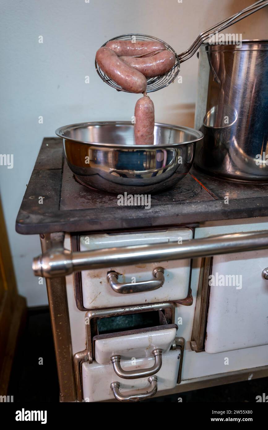 Eine Schüssel mit Luganighe Wurst auf einem alten Küchenherd in Lugano, Tessin, Schweiz Stockfoto