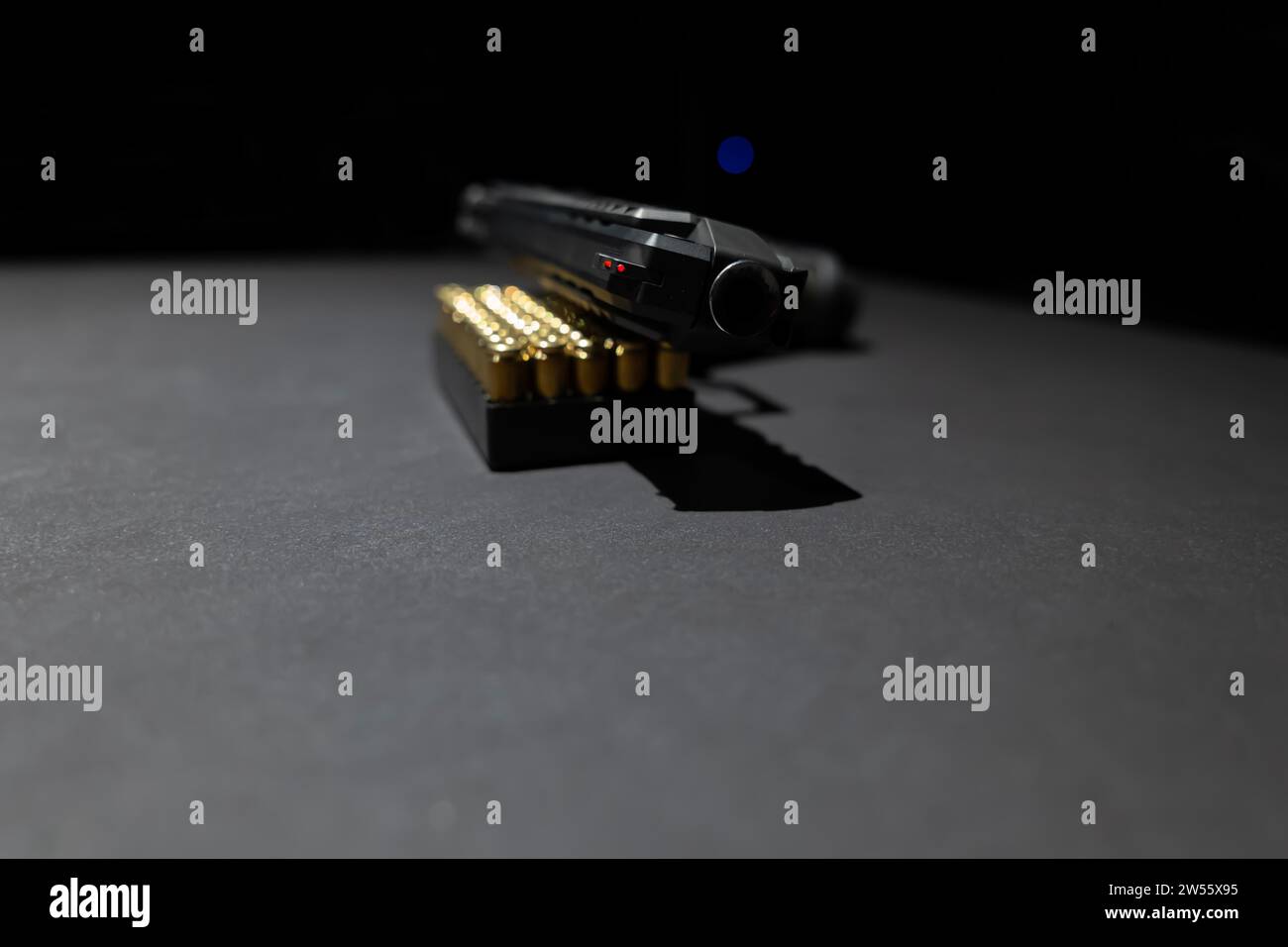 Moderne elegante Handfeuerwaffe, die auf Munition Bullet auf grauem Hintergrund in der Schweiz angelehnt ist Stockfoto