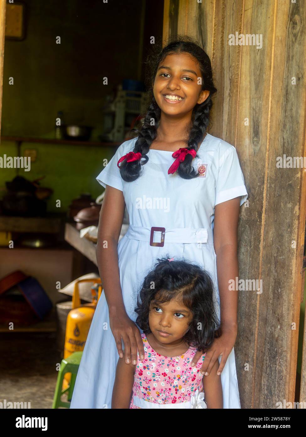 Singhalesisches Schulmädchen mit weißer Kleidung, schwarzen Zöpfen und roten Bändern, Sri Lanka Stockfoto