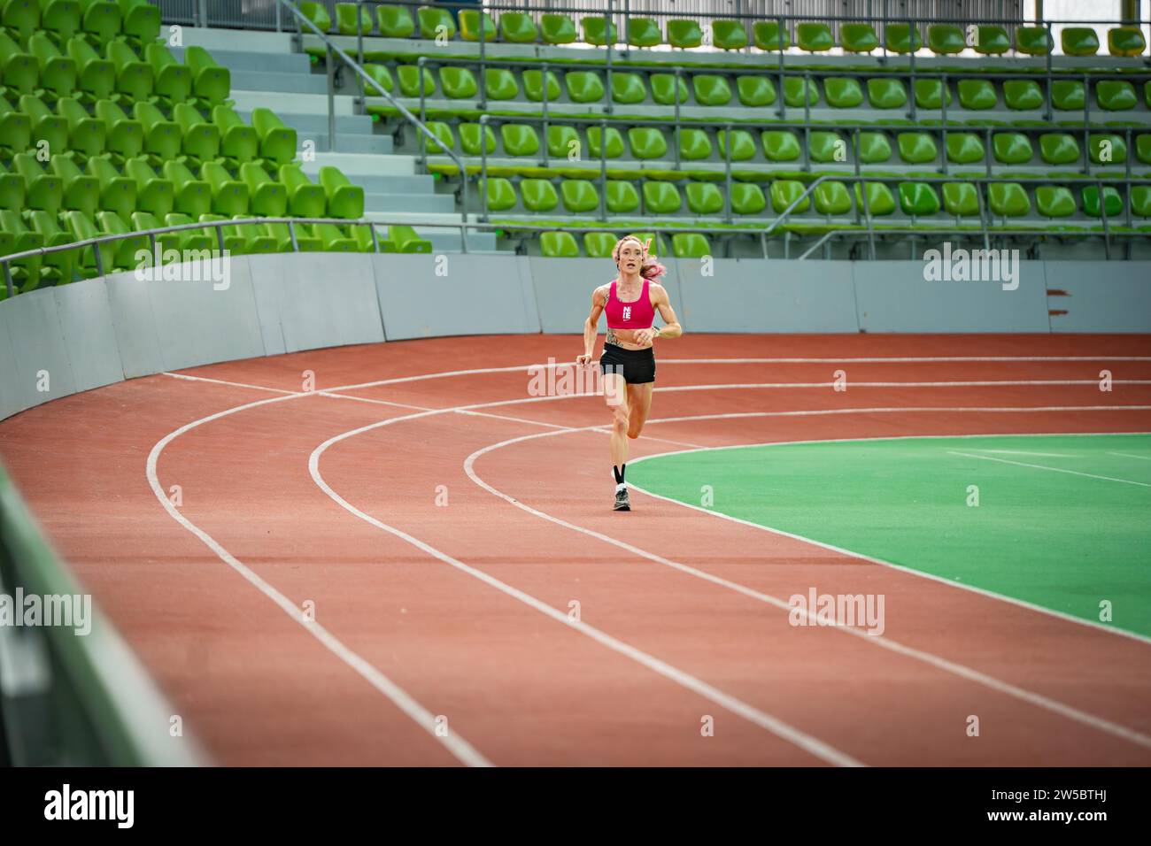 Blick auf eine leere Laufbahn in einem Stadion mit moderner Sportarchitektur und grünen Sitzen, Glaspalast, Sindelfingen Stockfoto