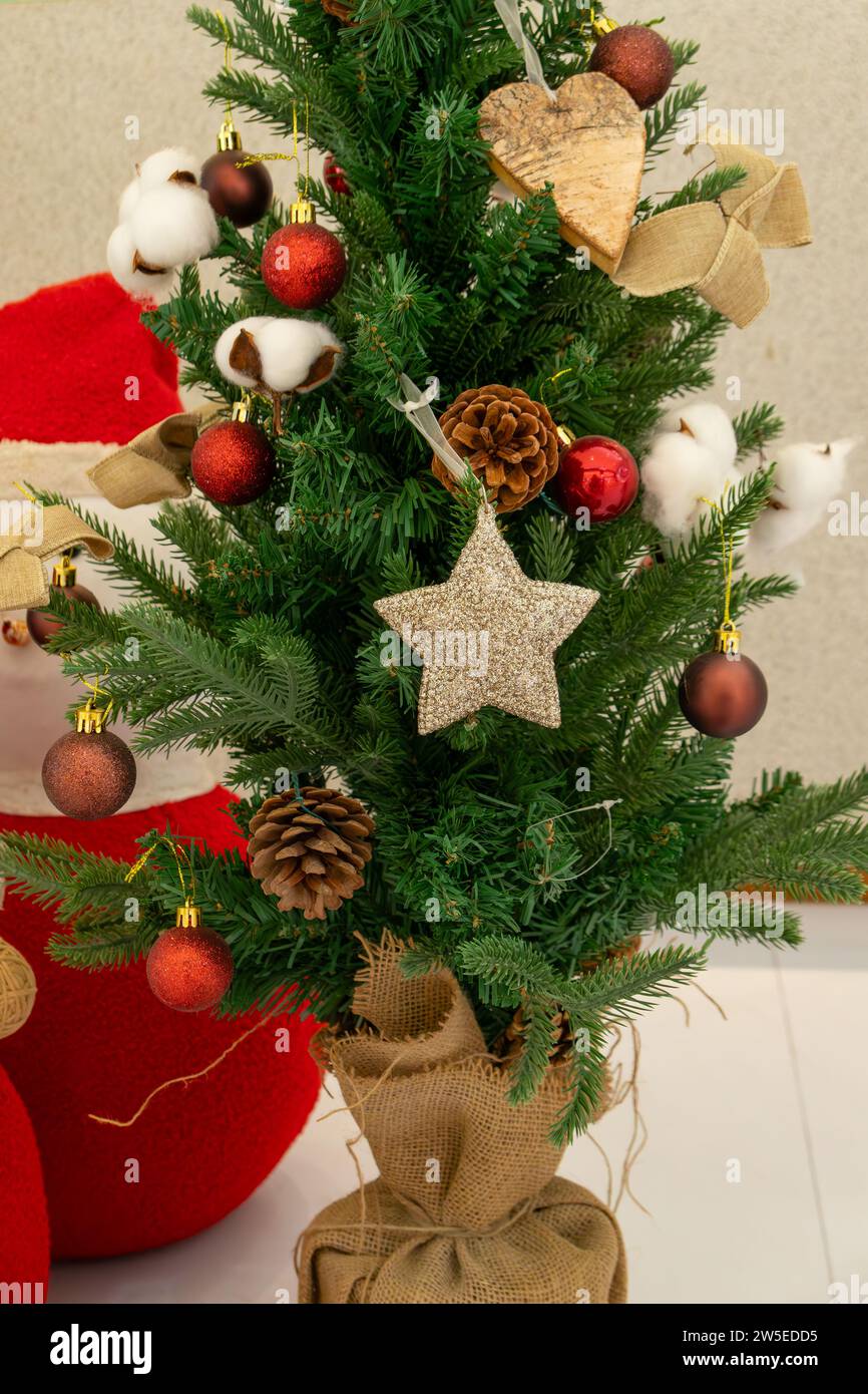 Kleiner Weihnachtsbaum mit Verzierungen in vertikaler Komposition Stockfoto
