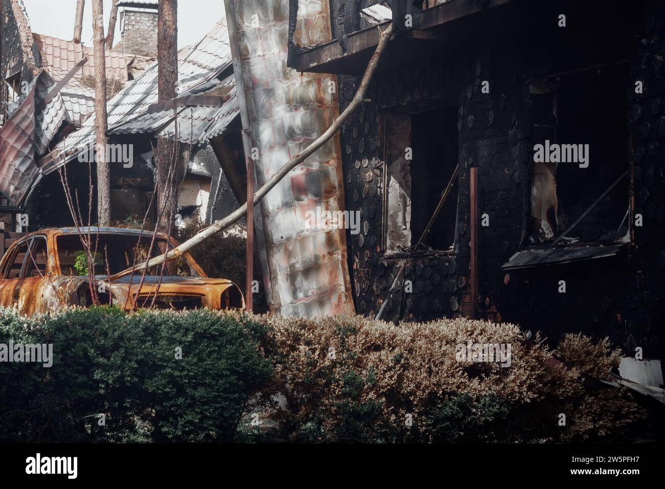 Irpin, Region Kiew, 2022. Zerstörtes Auto im Hof eines Hauses. Die Folgen des Raketenfeuers während des russischen Krieges gegen die Ukraine. Stockfoto