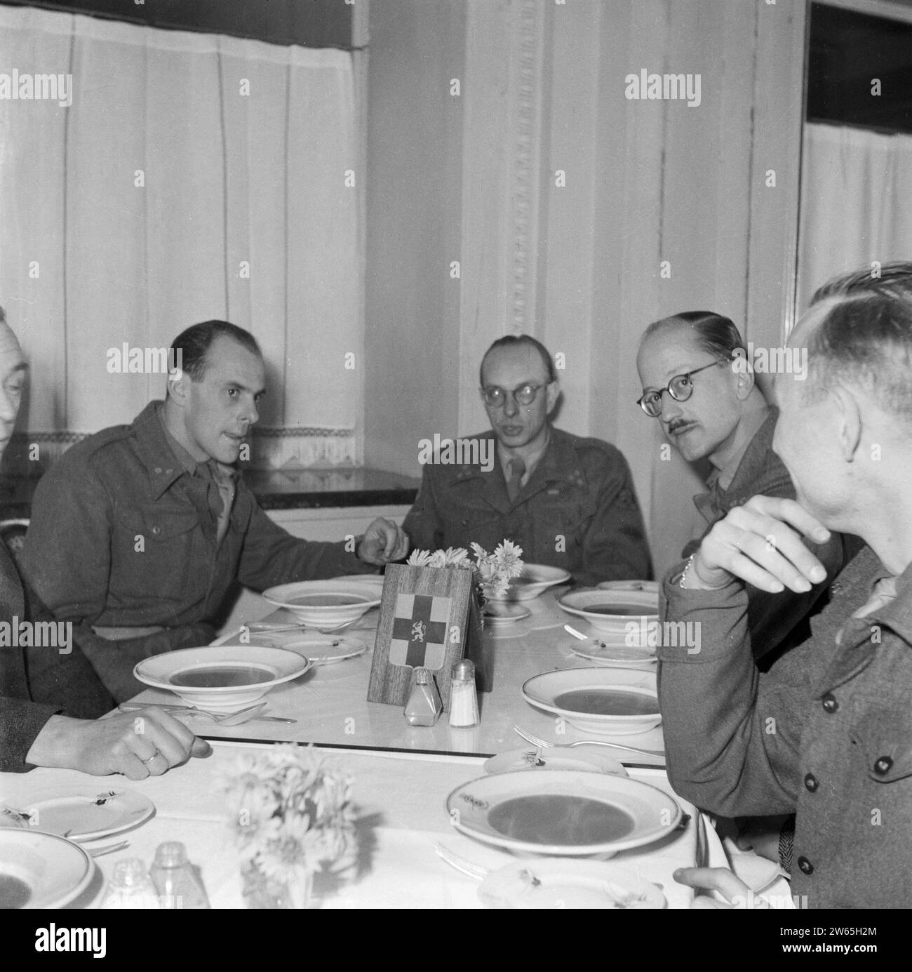 Verschiedene Offiziere von Prinz Bernhards Stab bei der Vorspeise bei einem gemeinsamen Abendessen, direkt zurück Captain Gerrie van Maasdijk CA. 1945 Stockfoto