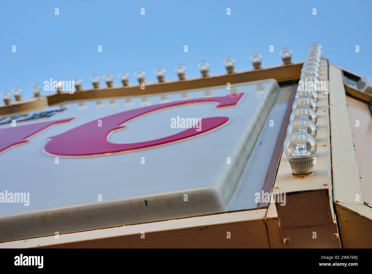 Vintage-Schild mit Glühbirnen und rotem Buchstaben C gegen blauem Himmel Stockfoto