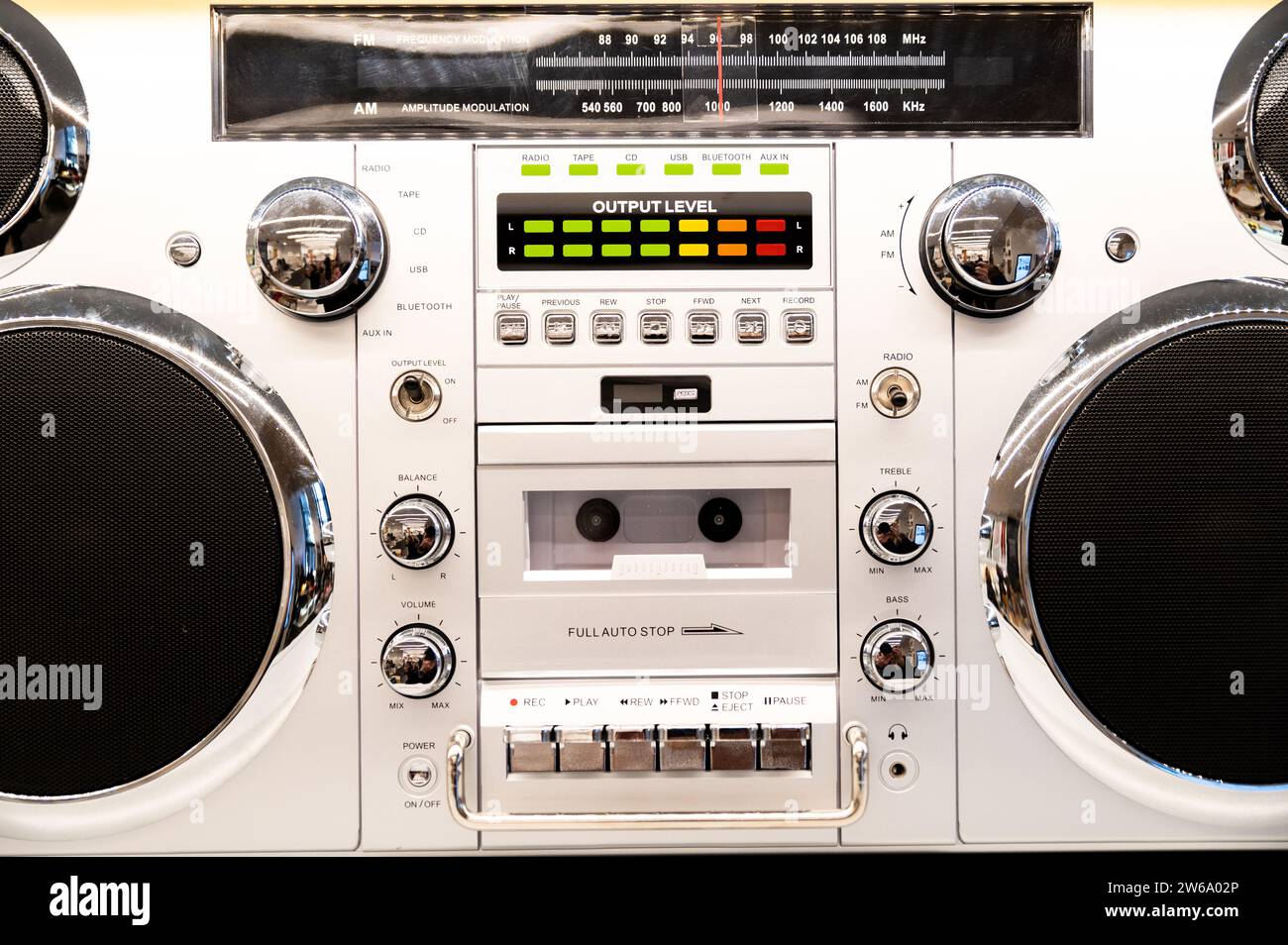 Nahaufnahme eines weißen altmodischen Radio- und Kassettenspielers mit farbenfroher Soundanzeige und schwarzen Lautsprechern vor weißem Hintergrund Stockfoto
