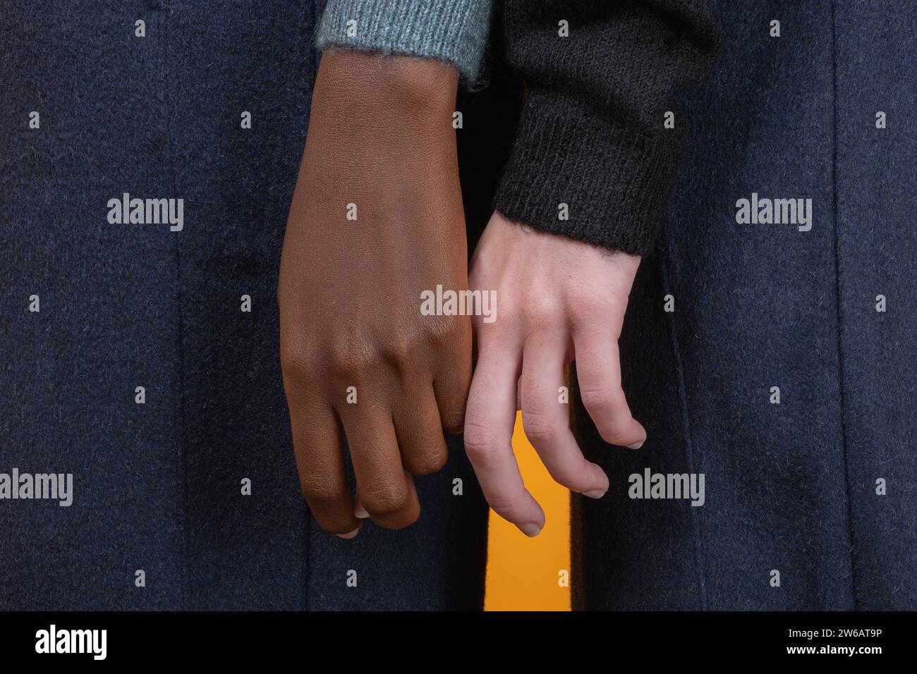 Seitenansicht der Mitte der modischen, multirassischen, nicht erkennbaren Frauen in legeren Kleidern, die vor gelbem Hintergrund zusammen stehen Stockfoto