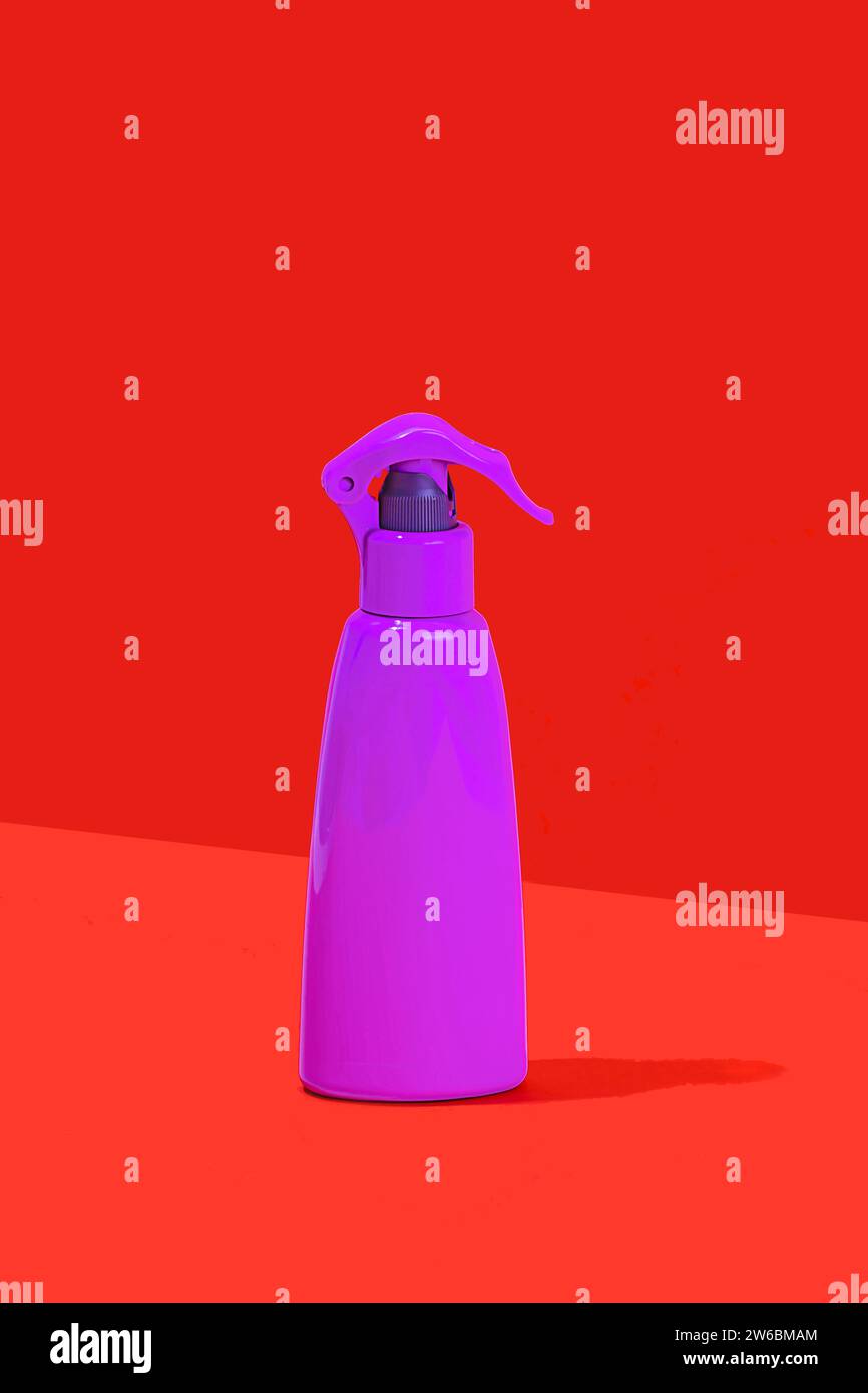 Ein minimalistisches Bild mit einer lila Sprühflasche mit einem Auslöser, das vor einem auffälligen roten Hintergrund steht und einen starken Farbkontrast erzeugt. Stockfoto