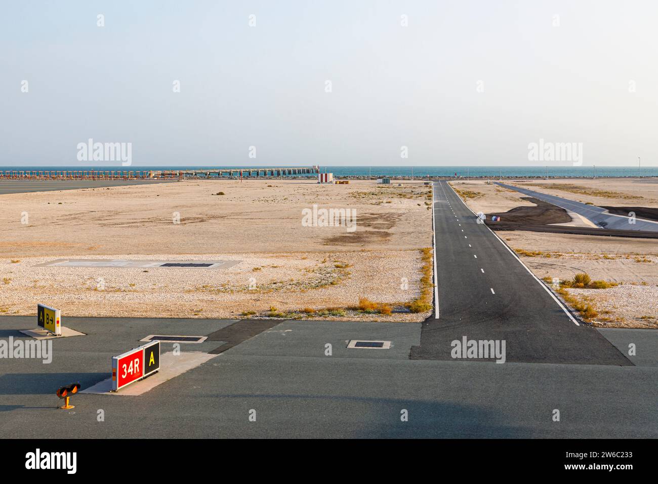 Eine Start- und Landebahn und die Küste am Hamad International Airport in Doha, Katar Stockfoto
