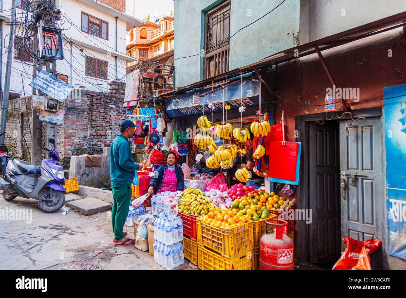Kleines lokales Geschäft am Straßenrand und Ladenbesitzer, der Obst und allgemeine Proviant im Bezirk Pashupatinath, Kathmandu, Hauptstadt von Nepal, verkauft Stockfoto