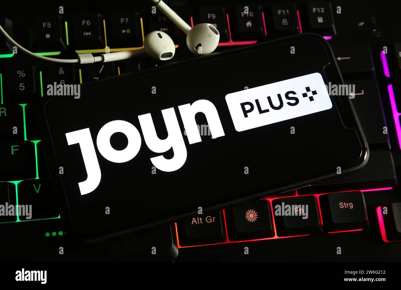 Viersen, Deutschland - 9. Dezember. 2023: Nahaufnahme des Smartphones auf Computertastatur mit Logo-Schriftzug von Joyn plus Streaming-Service Stockfoto