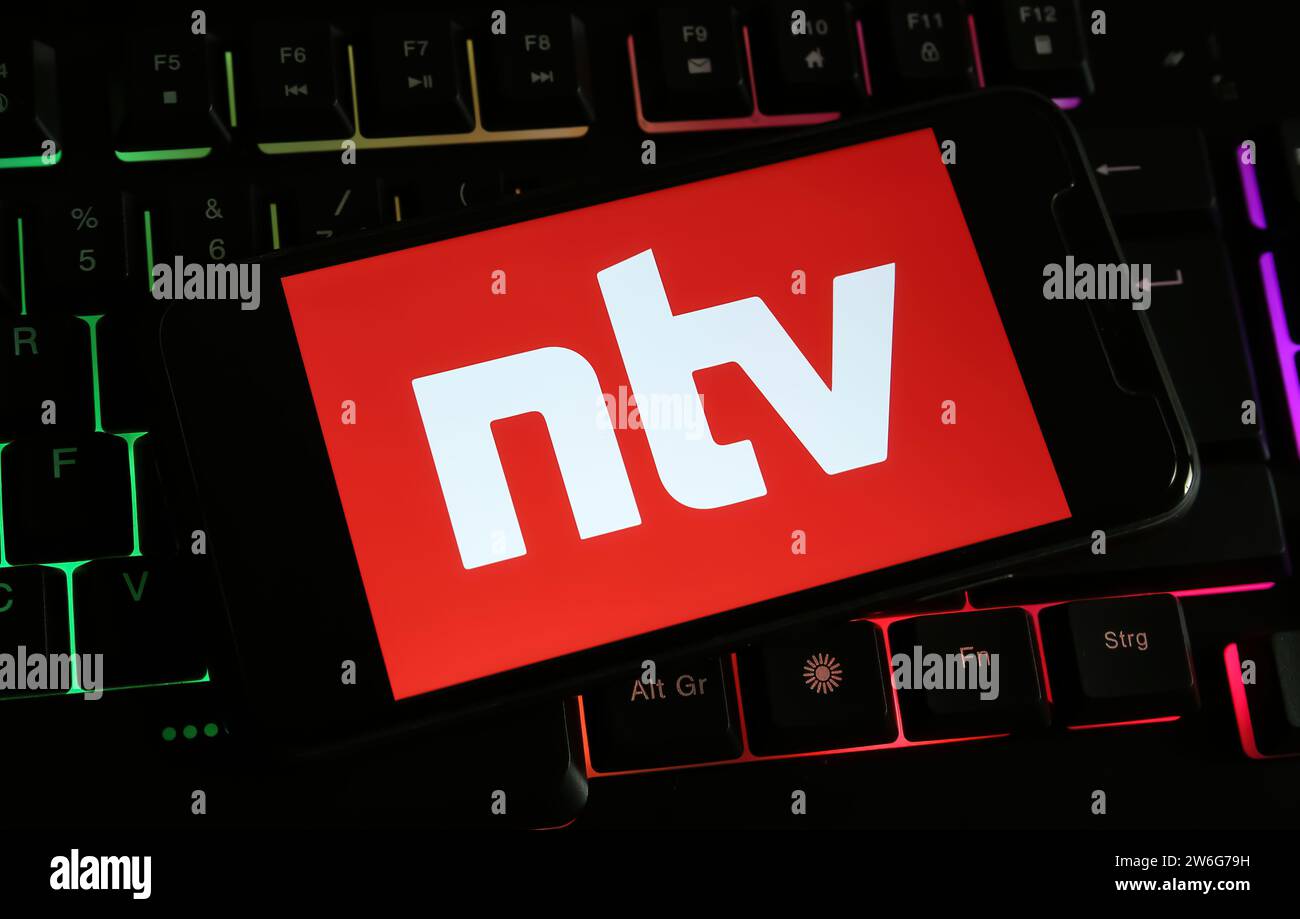 Viersen, Deutschland - 9. Dezember. 2023: Nahaufnahme des Smartphones auf Computertastatur mit Logo-Schriftzug des deutschen Fernsehsenders NTV Stockfoto